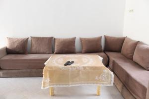 ein braunes Sofa mit einem Tisch im Wohnzimmer in der Unterkunft Studio in Oued Laou