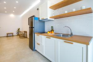 a kitchen with a sink and a refrigerator at Oasis Deluxe Studios in Pefkari