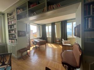 een woonkamer met boekenplanken en een tafel en stoelen bij L'attico del 1600 in centro in Perugia