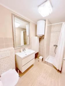 Baño blanco con lavabo y espejo en Home Apartments en Seline