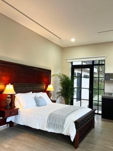 a bedroom with a large bed with a wooden headboard at 1714 Hotel Boutique Guatapé in Guatapé
