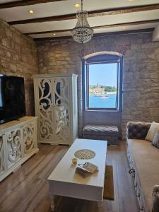 a living room with a couch and a table and a window at Luxury Seafront Suite Fabri in Vis