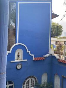 un edificio azul con un reloj en él en Villita San Gregorio, en Ciudad de México