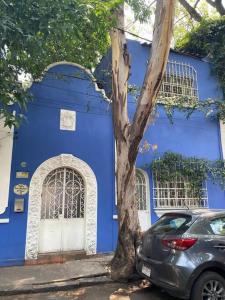 una casa azul con un coche aparcado delante de ella en Villita San Gregorio, en Ciudad de México