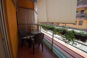 d'un balcon avec une table, des chaises et une fenêtre ornée de plantes. dans l'établissement Centar stan na dan za do 4 osobe, à Novi Sad