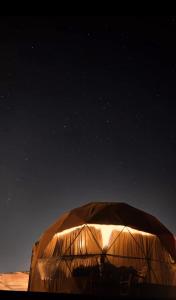 a lit up igloo under the night sky at Warm bubbles Wadi Rum in Wadi Rum