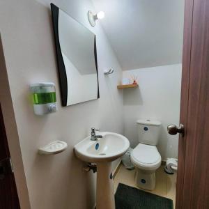 a bathroom with a sink and a toilet and a mirror at Casa Appushii Riohacha in Ríohacha
