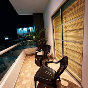 two black chairs sitting on a balcony at night at Casa Appushii Riohacha in Ríohacha