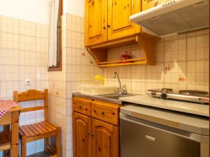 uma cozinha com armários de madeira e um lavatório em XENOFONTAS APARTMENTs em Agios Georgios Pagon