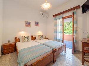 um quarto com 2 camas e uma janela em XENOFONTAS APARTMENTs em Agios Georgios Pagon