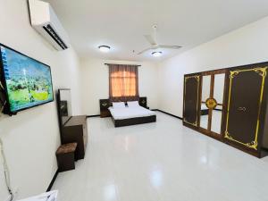 a room with a bed and a tv in it at البيت الأبيض للشقق المفروشة White House in Salalah