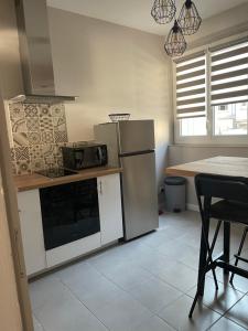 a kitchen with a refrigerator and a table at Le Cosy in Blois