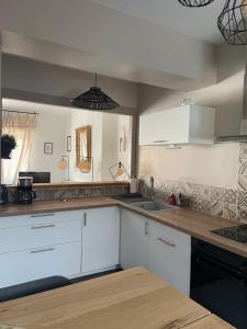 a kitchen with white cabinets and a sink at Le Cosy in Blois