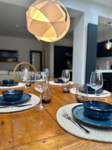 uma mesa de madeira com pratos e copos de vinho em Cosy spacious home by the water With free parking em Portsmouth