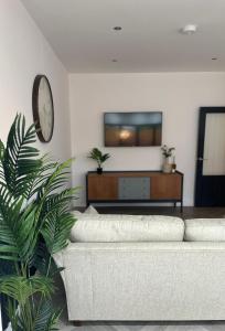 uma sala de estar com um sofá branco e uma televisão em Cosy spacious home by the water With free parking em Portsmouth