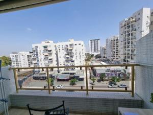 a balcony with a view of a city with buildings at Charming Warm and Sun-Filled 1 and 2 Bedroom Apartment in Ashdod