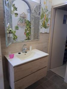a bathroom with a sink and a mirror at Charming Warm and Sun-Filled 1 and 2 Bedroom Apartment in Ashdod