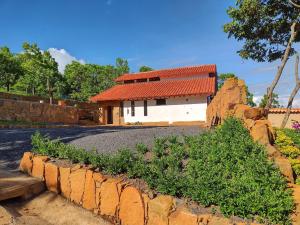 une maison avec un toit rouge et un mur en pierre dans l'établissement Color Marron casa de campo, à Barichara