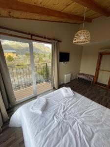 um quarto com uma cama branca e uma grande janela em Free Mountain em San Carlos de Bariloche