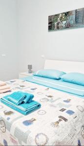 - une chambre avec 2 lits et des serviettes bleues sur le lit dans l'établissement Garden Apartment, à Pescara