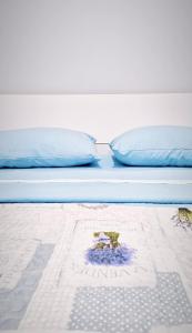 - un lit avec des oreillers bleus et une plante dans l'établissement Garden Apartment, à Pescara