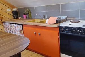 a kitchen with a sink and a stove at Studio La bohéme in Saint-Sylvain-Bellegarde