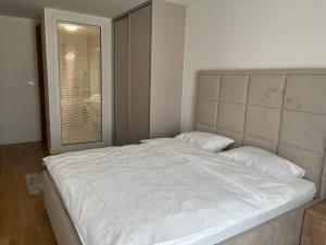 - un lit blanc dans une chambre avec fenêtre dans l'établissement River Walk Sarajevo 608, à Sarajevo