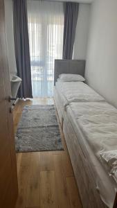 - une chambre avec un lit, un tapis et une fenêtre dans l'établissement River Walk Sarajevo 608, à Sarajevo