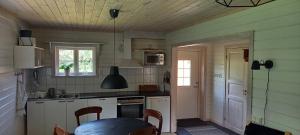 Sollerön的住宿－Vackert belägen lägenhet i Gesunda，厨房配有白色橱柜和桌子