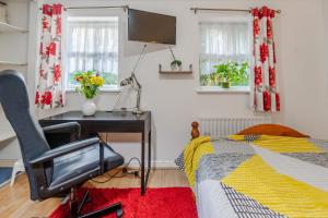 a bedroom with a bed and a desk and a television at Super room with free parking 400 Mbps Internet in London