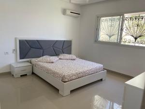 een slaapkamer met een bed en een raam bij Belle Villa Avec Piscine sans vis a vis in Midoun