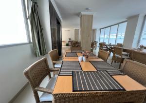 a row of tables in a restaurant with chairs at Hotel Caribe Rodadero in Santa Marta