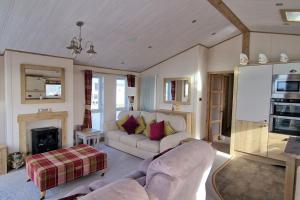 ein Wohnzimmer mit Couch und Kamin in der Unterkunft Sea View Lodge, Seal Bay Resort, Selsey in Selsey