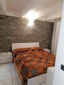a bedroom with a bed and a brick wall at Centro Storico MARE FUORI in Brindisi