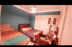 a small bedroom with two beds and a lamp at ( Apartment on the sea in Alexander (Montazah district in Alexandria