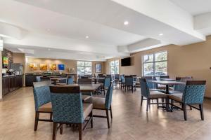 a restaurant with tables and chairs and a kitchen at Comfort Suites Medical Center near Six Flags in San Antonio