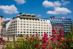 Un edificio blanco con flores rosas delante. en Radisson RED Hotel, Vienna, en Viena