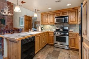 a kitchen with wooden cabinets and a stove at The Lodges at Deer Valley AC 5323 and 5423 in Park City