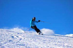a person is skiing down a snow covered slope at The Lodges at Deer Valley AC 5323 and 5423 in Park City
