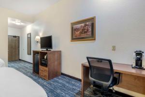 キーストーンにあるComfort Inn & Suites Mt Rushmoreのベッド、デスク、テレビが備わるホテルルームです。