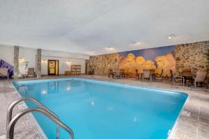Comfort Inn & Suites Mt Rushmore في كيستون: مسبح في فندق فيه لوحة على الحائط