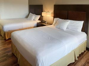 - 2 lits dans une chambre d'hôtel avec des draps blancs dans l'établissement Motel 6 Fancy Gap VA, à Fancy Gap