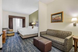 Comfort Inn & Suites Mt Rushmore في كيستون: غرفه فندقيه بسرير واريكه