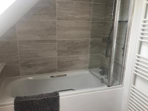 a bathroom with a bath tub with a shower at Sea dream lodge -coastal location/sea views/self-contained in Southerndown