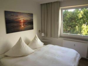 ヴェスターラントにあるApp-Rimmler-Suedstrandperleの白いベッド(枕付)が備わる窓付きのベッドルームです。
