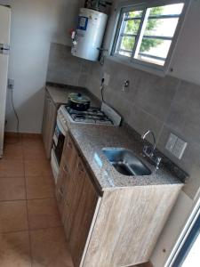 a kitchen with a sink and a stove at Departamento "Juana"para 4 personas 2 cuartos con garage en Santa Teresita in Santa Teresita