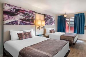 Habitación de hotel con 2 camas y cortinas azules en Heights House Hotel, Ascend Hotel Collection en Houston