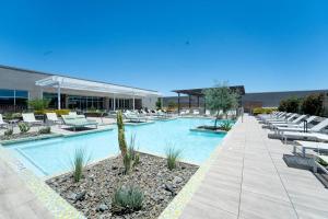 una piscina con tumbonas y un edificio en ASU Sun Devil Luxury Apt, Rooftop Pool & Gym!, en Tempe