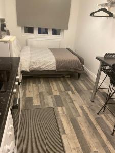 a bedroom with a bed and a desk and a table at Exeter Garden for 2 in Ilford
