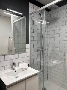 La salle de bains blanche est pourvue d'une douche et d'un lavabo. dans l'établissement Le Belvédère, à Orléans